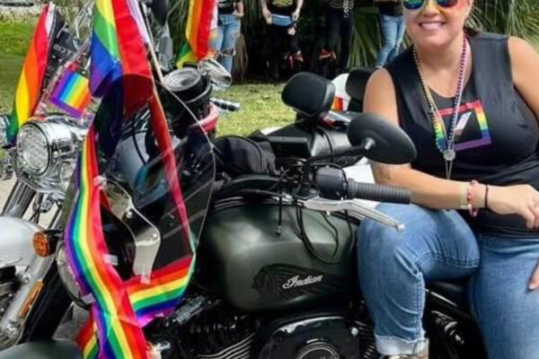 Female on her black motorcycle with pride flags